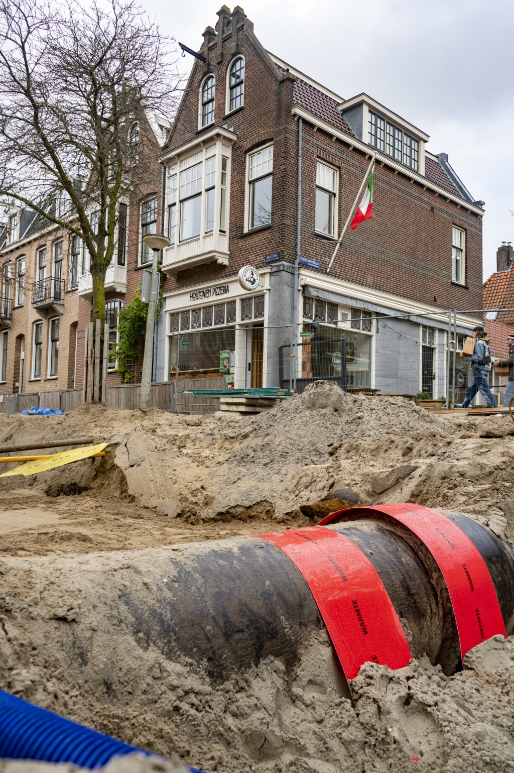 Straat die openligt waar een warmtenetbuis zichtbaar is