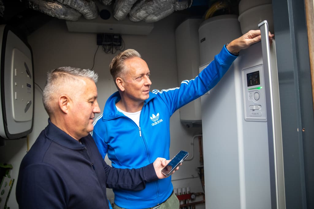 Twee mannen naast een warmtepomp