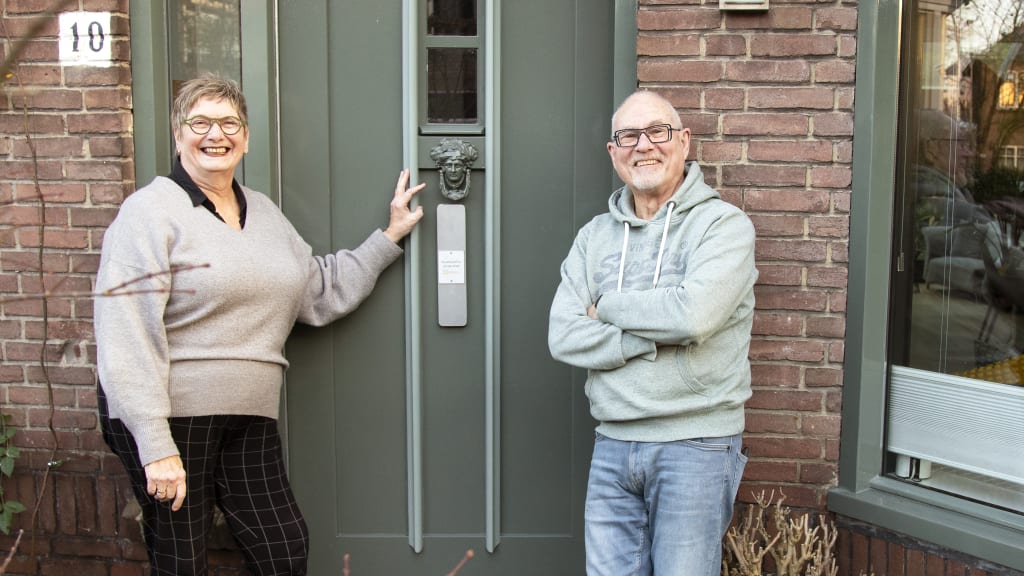 Een man en een vrouw die voor een deur poseren.