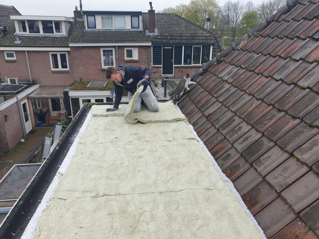 Man legt onderlaag groendak op uitbouw