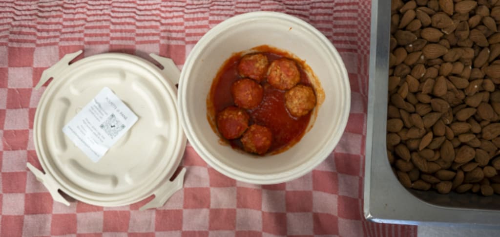 Gehaktballetjes in rode saus met een bak amandelen ernaast