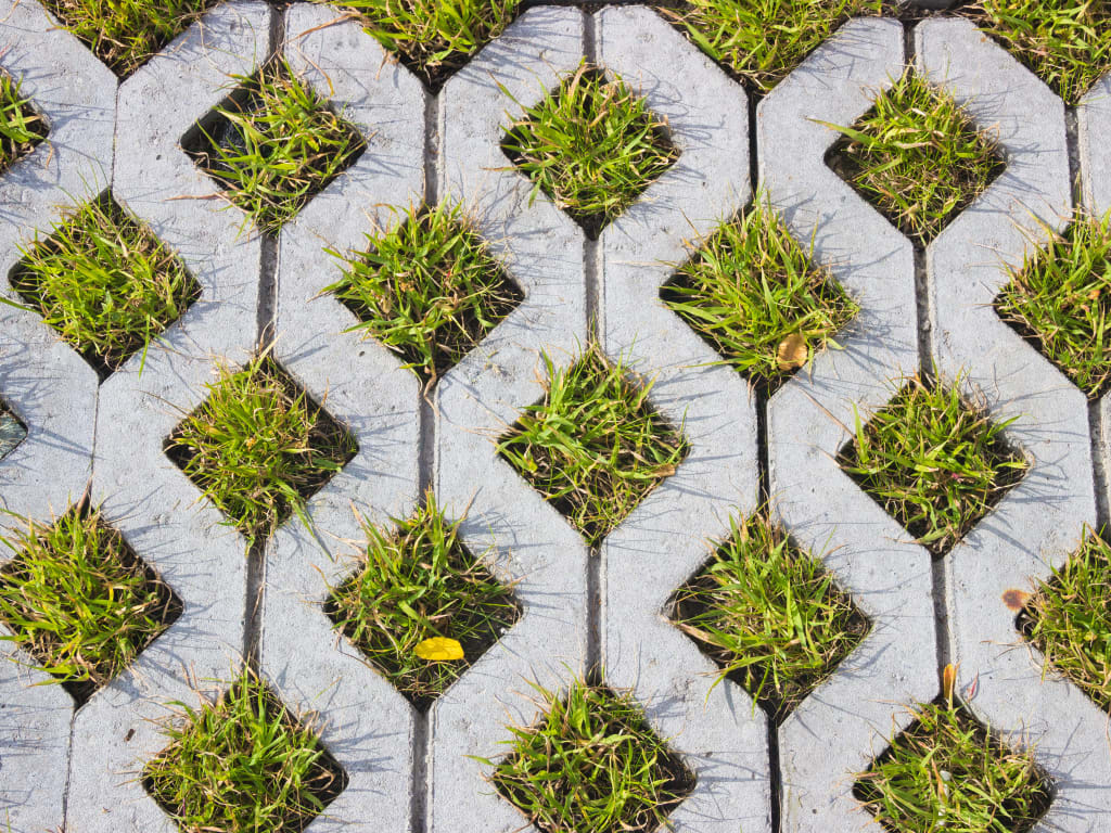 Grasbetontegels van bovenaf gezien met gras dat er doorheen groeit