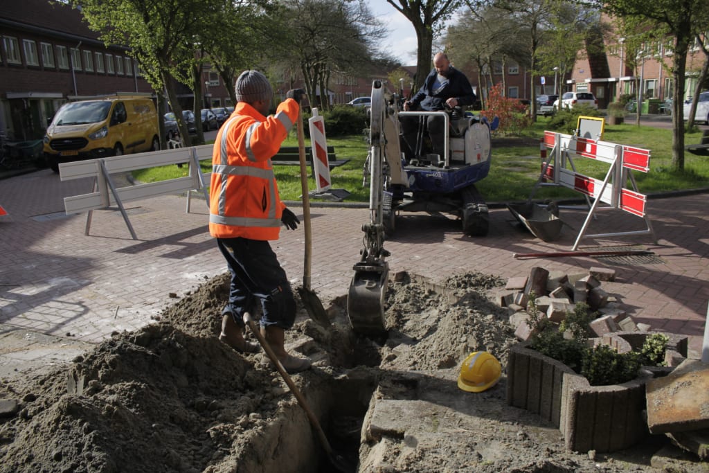 Werklui zijn aan het graven om een gasleiding bij een woning af te sluiten.