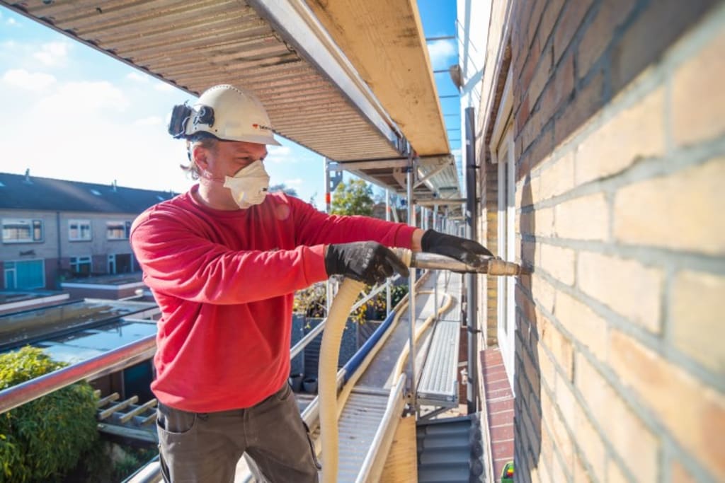 Man op steiger plaats spouwmuurislatie