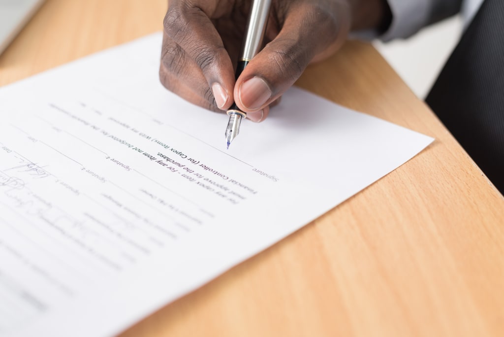 Afbeelding van hand met pen die offerte aan het ondertekenen is.