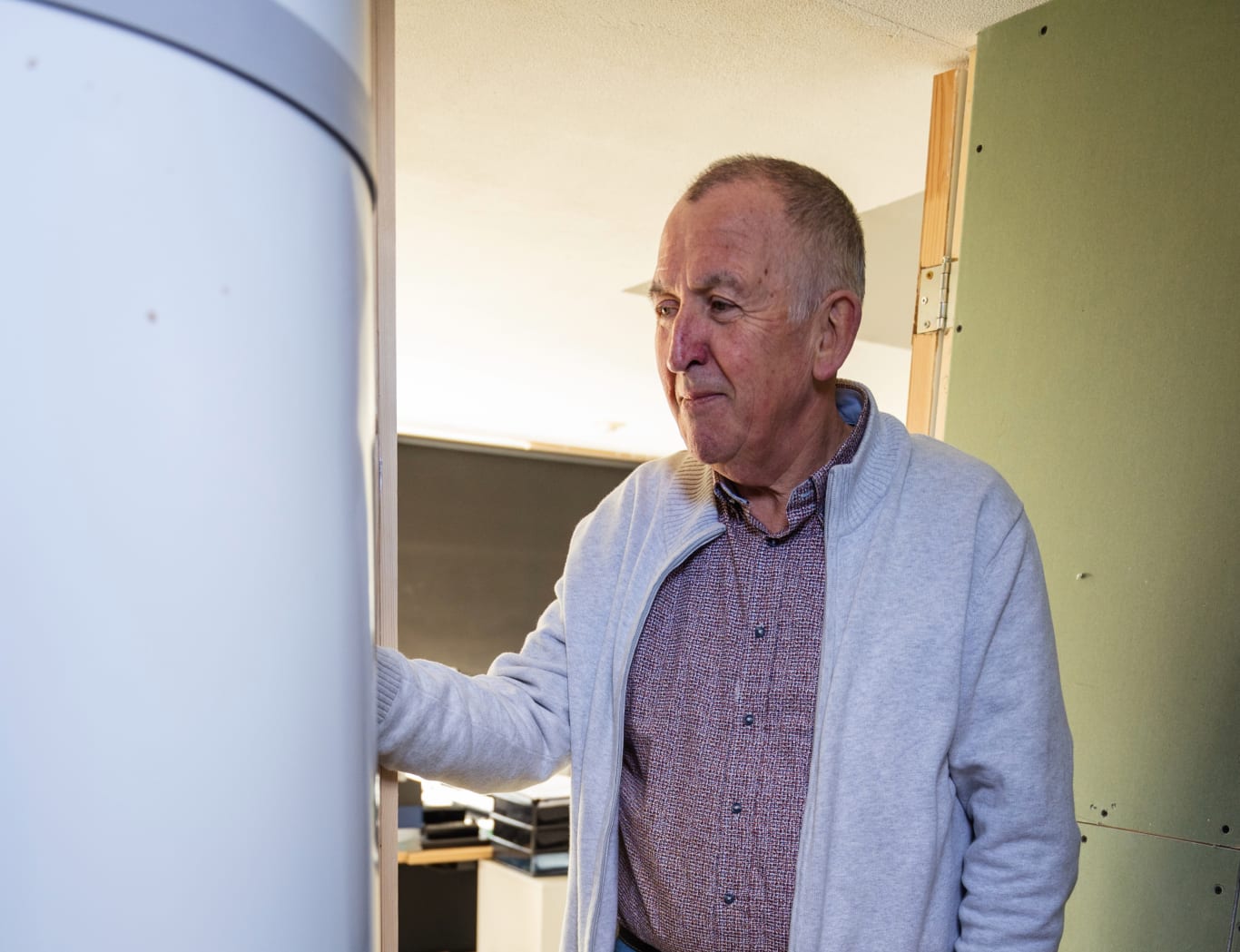 Meneer op de foto naast warmtepomp