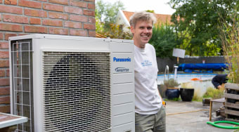 Meneer naast een warmtepomp