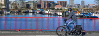 Man fietst over een brug bij Zeeburgereiland in Amsterdam