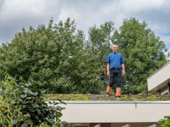 Foto van een man die op een dak staat