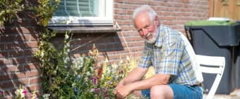 Foto van een man op een tuinstoel