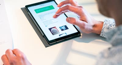 Persoon bezig met een tablet op een tafel