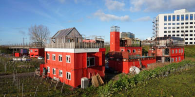 Rood geschilderde houten gebouwtjes in de tuin van Bret bij Amsterdam Sloterdijk