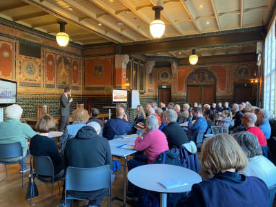 Spreker met publiek in een zaal