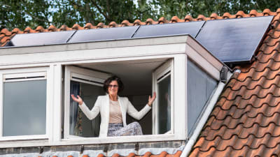 Foto van een vrouw die voor een raam staat.