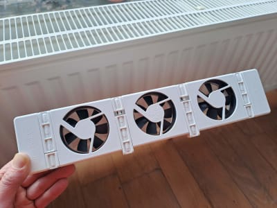 Radiatorventilator die voor een verwarming wordt gehouden