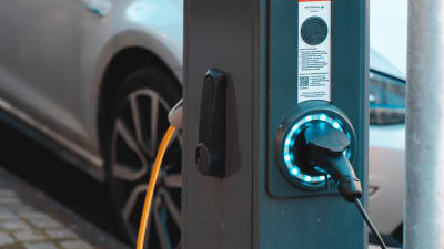 Elektrische auto die opgeladen wordt aan een laadpaal.