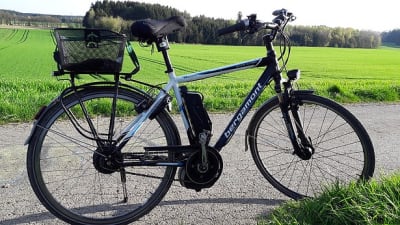 Elektrische fiets staat stil op fietspad met weiland erachter