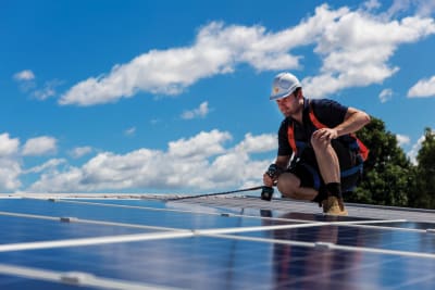 Vakspecialist is bezig met zonnepanelen monteren.