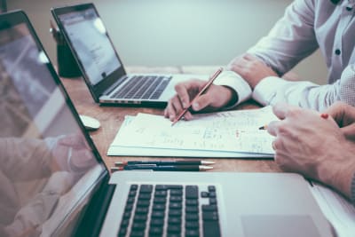 Twee laptops met papieren ertussen