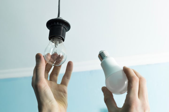 Hand vervangt gloeilamp voor halogeenlamp