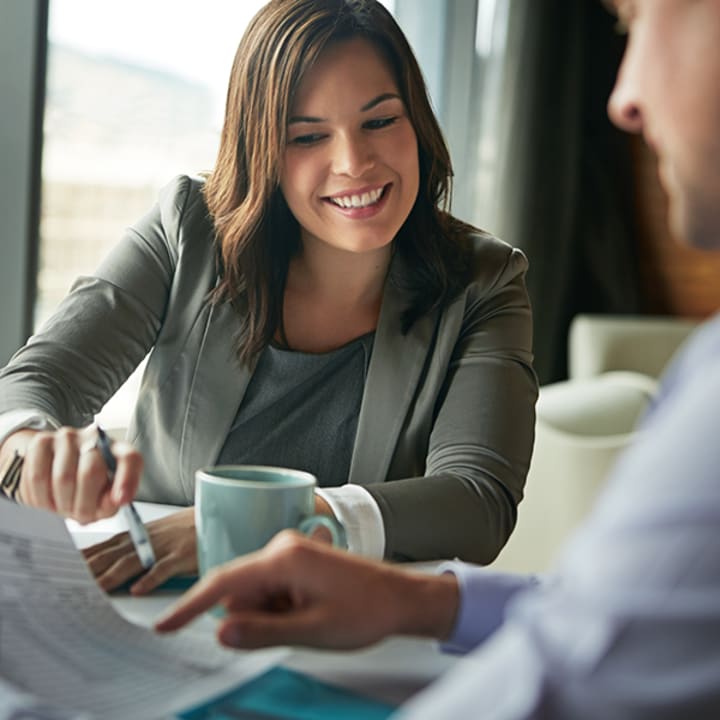 Vrouw wijst naar papieren bij financieel advies