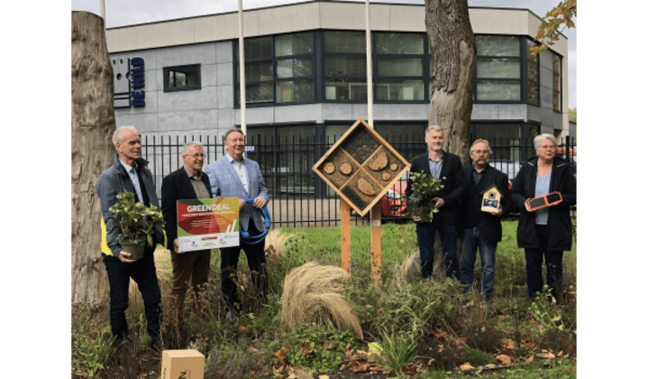 Afbeelding Roosendaal Green Deal Majoppeveld. Ondernemers staan bij insectenhotel.